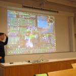 Herr Cornelius Müller rundete den Workshoptag als zweiter Gastredner ab - Im Hintergrund ein Sreenshot des Spiels World of Warcraft.